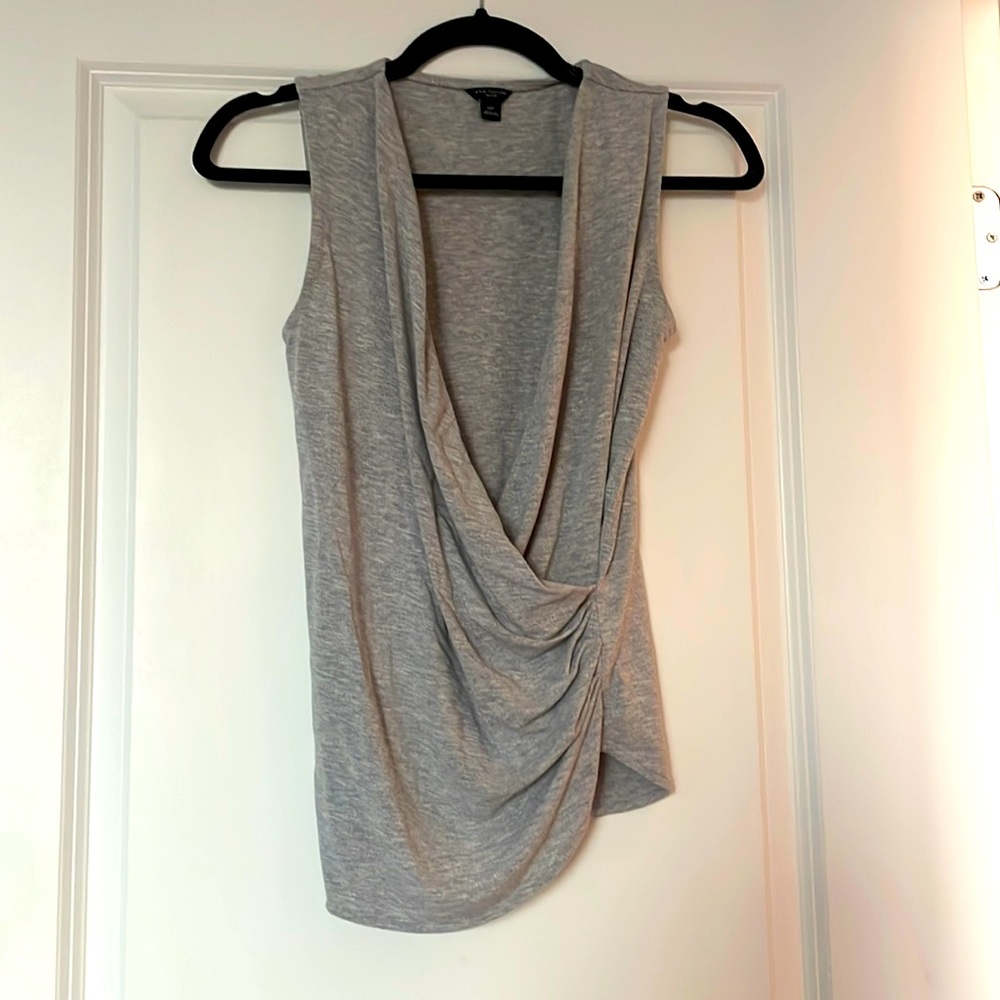 Gray sleeveless faux-wrap shell with ruched detailing on one side.